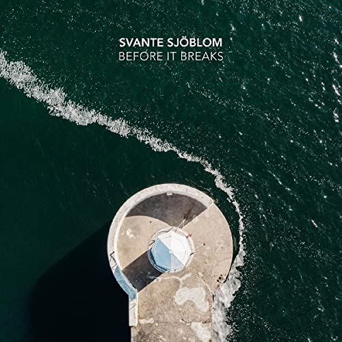 CD cover: Aerial view of a lighthouse surrounded by dark, wavy water.