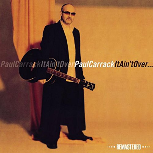 "Paul Carrack holding a guitar, wearing sunglasses and a black suit, on album cover."