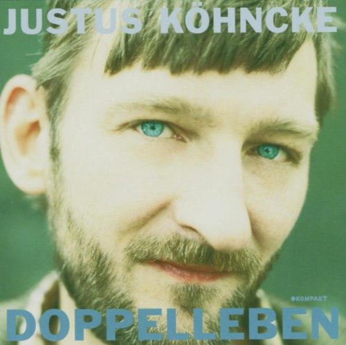 Man with blue eyes and short brown hair and beard, green background, album cover.