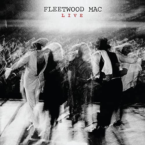 Black and white motion-blurred photo of Fleetwood Mac performing on stage.