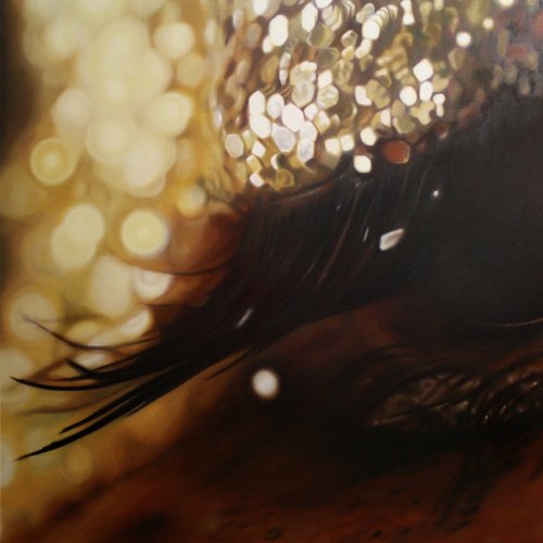 A close-up image of a black feather against a gold sequined background.