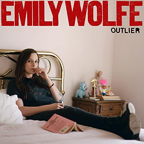 Album cover for Emily Wolfe’s “Outlier” featuring a woman on a bed.