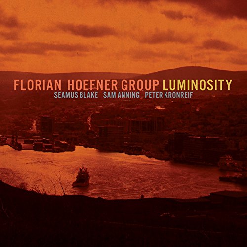 "Album cover with orange-toned cityscape and boats, featuring artist and title text."