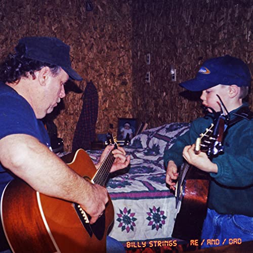 Two men with guitars, a father and son, playing music indoors.