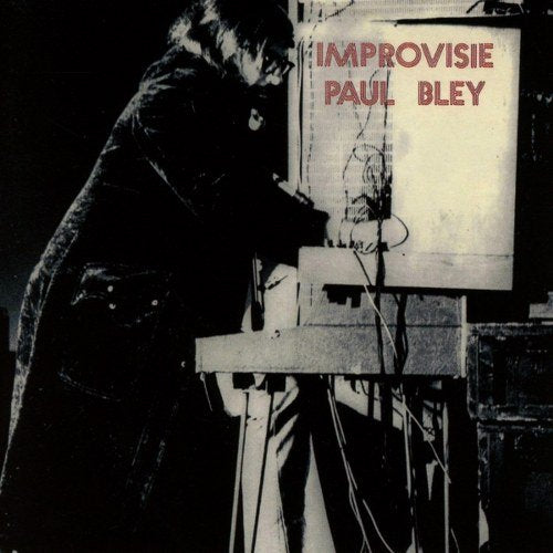 Black and white image of man at electronic keyboard with red text overlay on album cover.