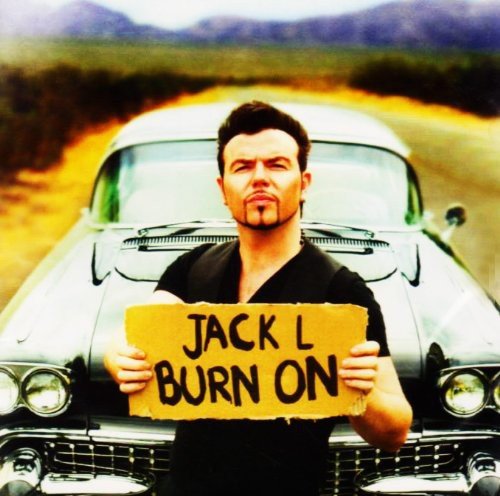 Jack L holding a sign in front of a classic car.