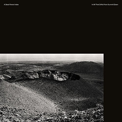 Black and white landscape album cover with rocky hills and a barren terrain.