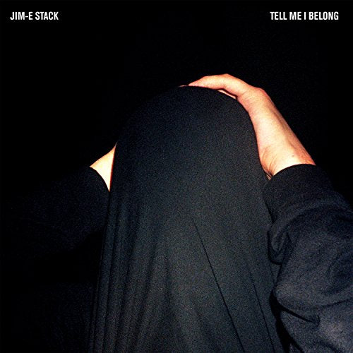 "Album cover featuring a person in black clothing with their head bowed down."