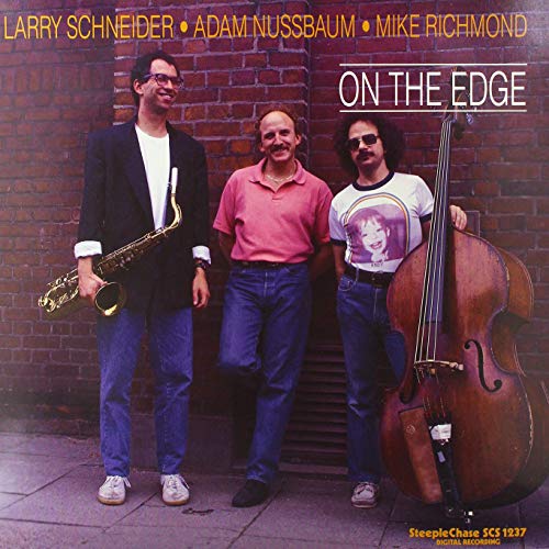Jazz musicians with instruments pose in front of a brick wall.