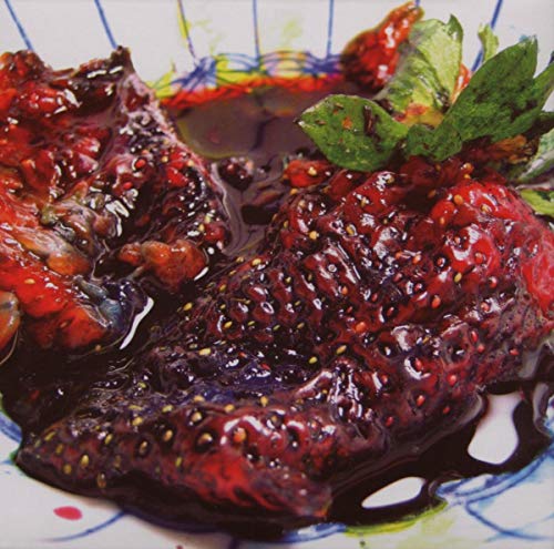 Close-up of strawberries and jam on a patterned white plate.