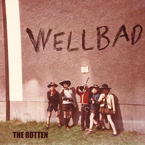 "Album cover with five men in cowboy hats standing by a concrete wall."