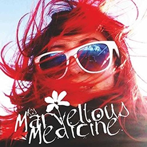 Person with red hair and sunglasses, album cover with white flower.