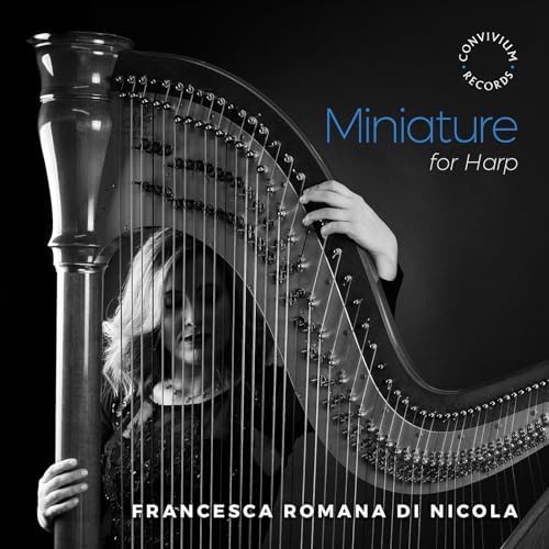 Harp strings and a partial view of a harpist in grayscale.