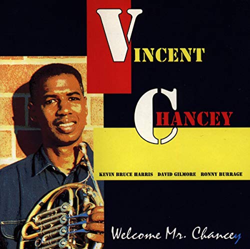 "Album cover with a man holding a French horn, colorful geometric background."