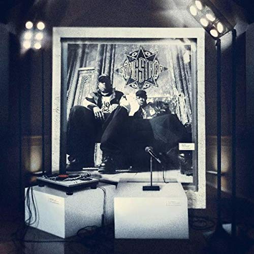 "Gang Starr album cover displayed with turntable and microphone on pedestals, under stage lights."