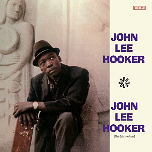 Album cover with John Lee Hooker sitting by a statue, wearing a fedora and suit.