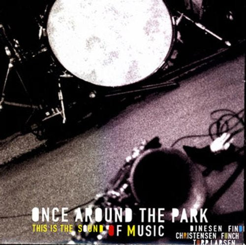 "CD cover featuring a drum kit on a grey floor, with text overlay."