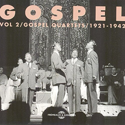 "Black and white image of a gospel quartet performing on stage, suits and microphones."
