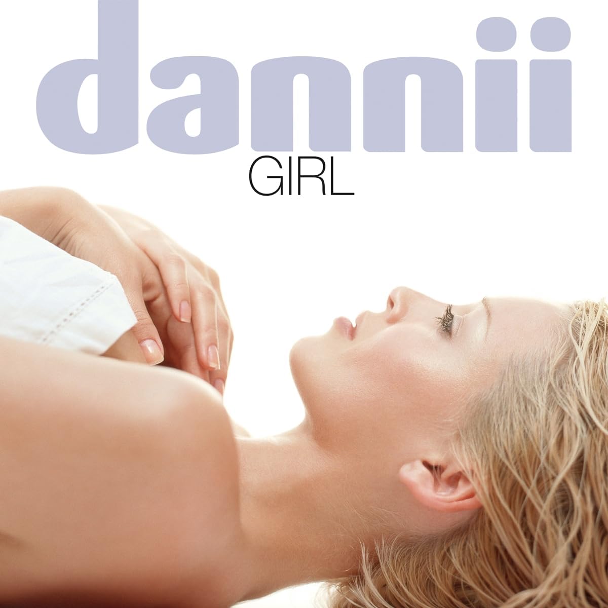 Dannii Minogue “Girl” album cover: blonde woman lying down, pale background.