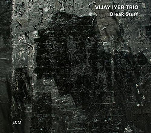 "Album cover with dark, textured background and white text 'Vijay Iyer Trio Break Stuff'."