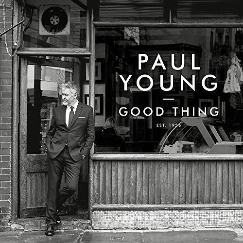 "Black and white album cover with man in suit standing in a doorway."