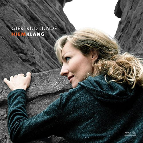 "CD cover featuring a woman in a dark sweater leaning against a rocky cliff."