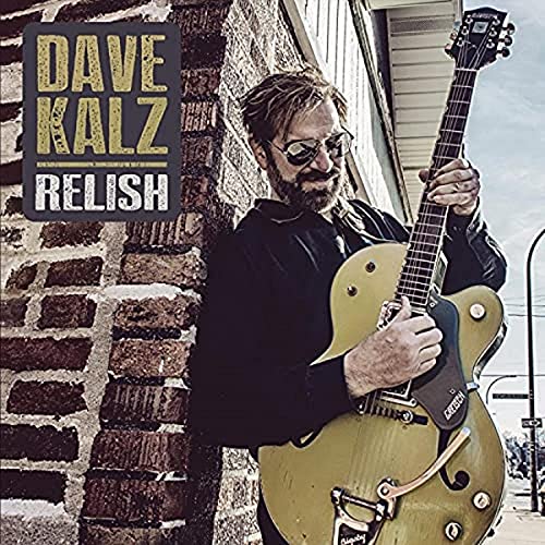 "Album cover: man holding gold guitar, leaning against brick wall, with text overlay."