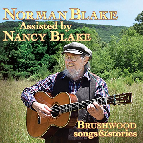 "Album cover with a man playing guitar in a green field."