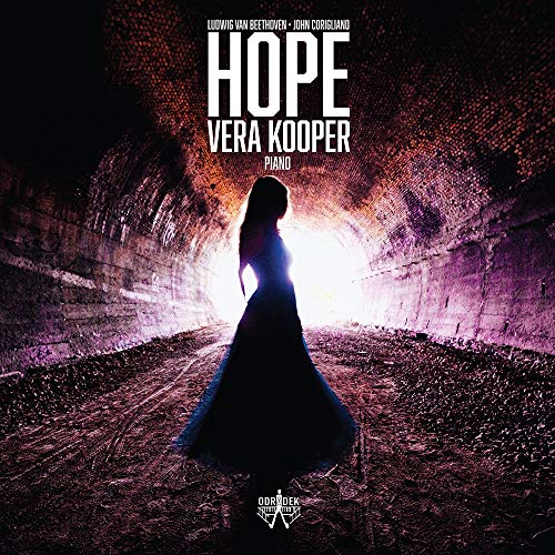 The image depicts a woman in a long dress standing in a tunnel with bright light.
