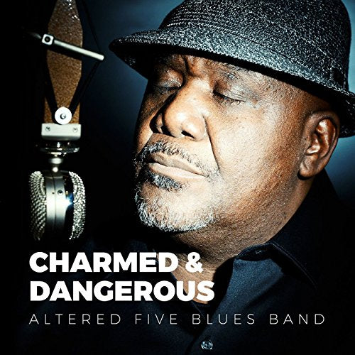 Album cover with man wearing fedora, singing into a microphone, against a dark background.