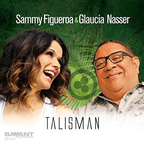 "Album cover with a man and woman smiling, green leafy background, titled 'Talisman'."