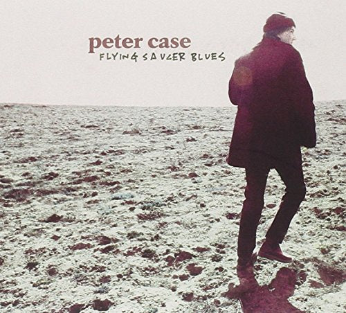 "Album cover featuring a man walking on a rocky, snowy terrain, wearing dark clothing."