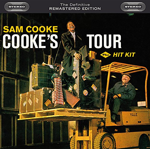 Sam Cooke sits on luggage atop a forklift driven by a man at night.