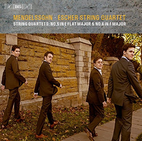 "CD cover featuring four men in suits walking along a stone wall."