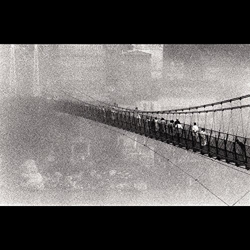 Black and white photo of people walking across a long rope bridge.