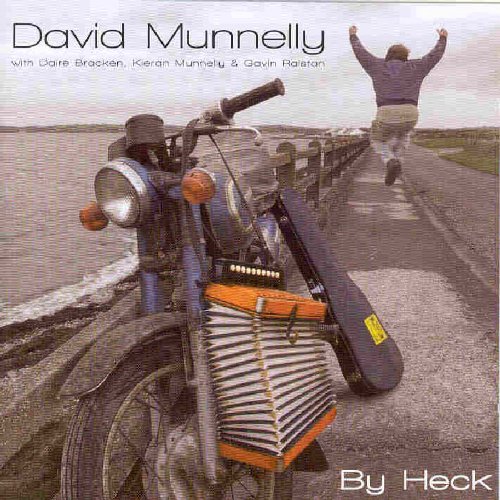 "Album cover with man jumping on a road, motorcycle with accordion attached."
