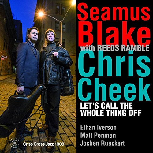 "CD cover with two men standing on a brick street at night, holding instrument cases."
