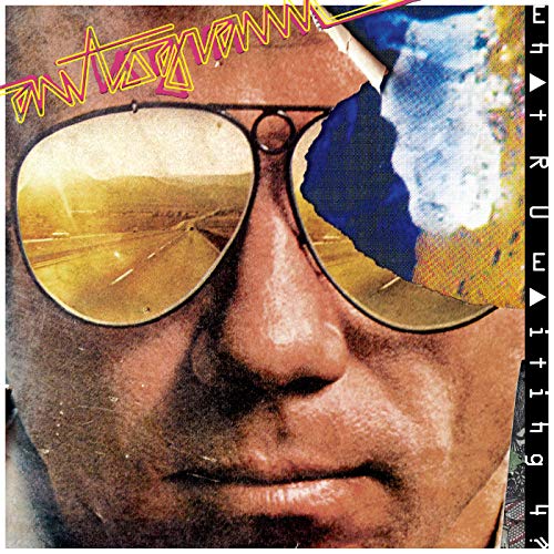 Close-up of a person wearing sunglasses reflecting a desert highway.