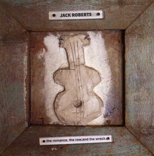 A carved violin on a wooden panel with artist's name and album title.