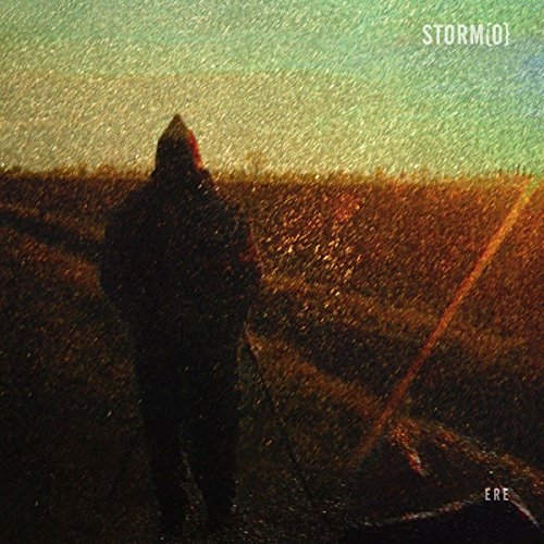 A silhouetted figure stands in a field during a rainstorm at sunset.