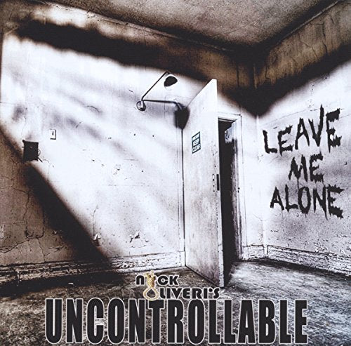 "Album cover with dimly lit room, open door, and 'leave me alone' graffiti on wall."