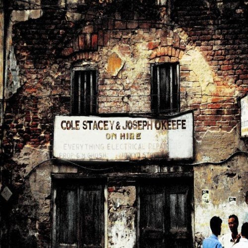 "Album cover featuring a distressed brick building with a sign reading 'Cole Stacey & Joseph Okeefe'."