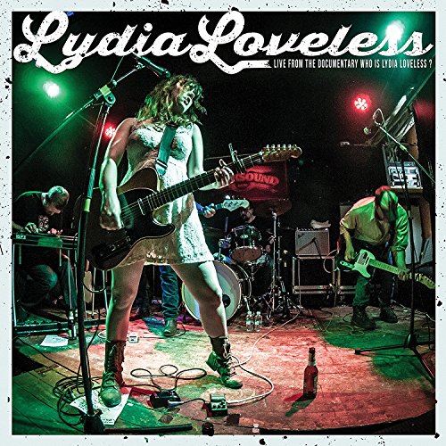 Lydia Loveless performing live with a band on a dimly lit stage.