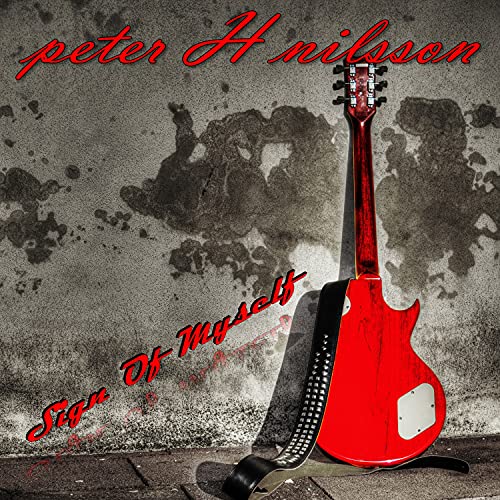 Red electric guitar leaning against a mottled gray wall.