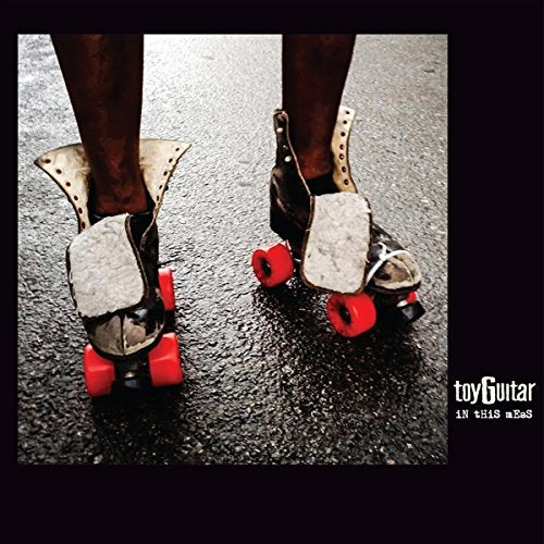 Roller skates on asphalt with album title "Toyguitar - In This Mess".