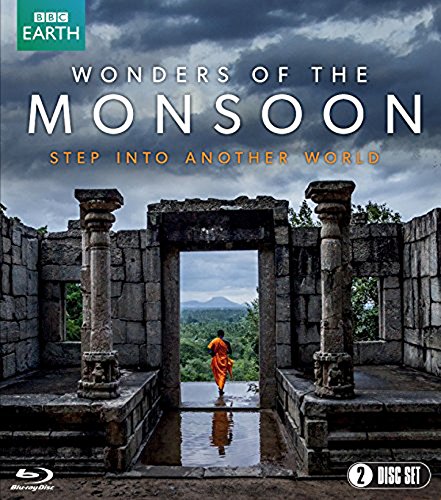 A monk in orange robes walks through stone ruins under a stormy sky.
