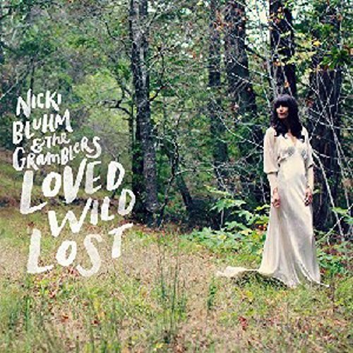 "Album cover featuring a woman in a white dress standing in a forest."