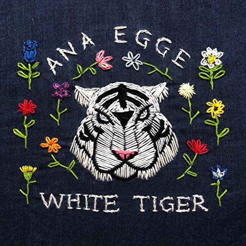 Embroidered tiger face with flowers on a dark blue denim background.