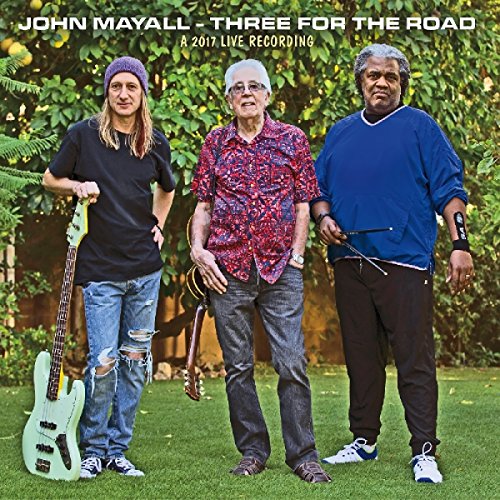 "Album cover featuring three men standing in a garden, holding guitars."