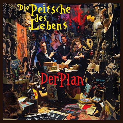 "Album cover with three men at a cluttered desk, surrounded by various objects and artwork."